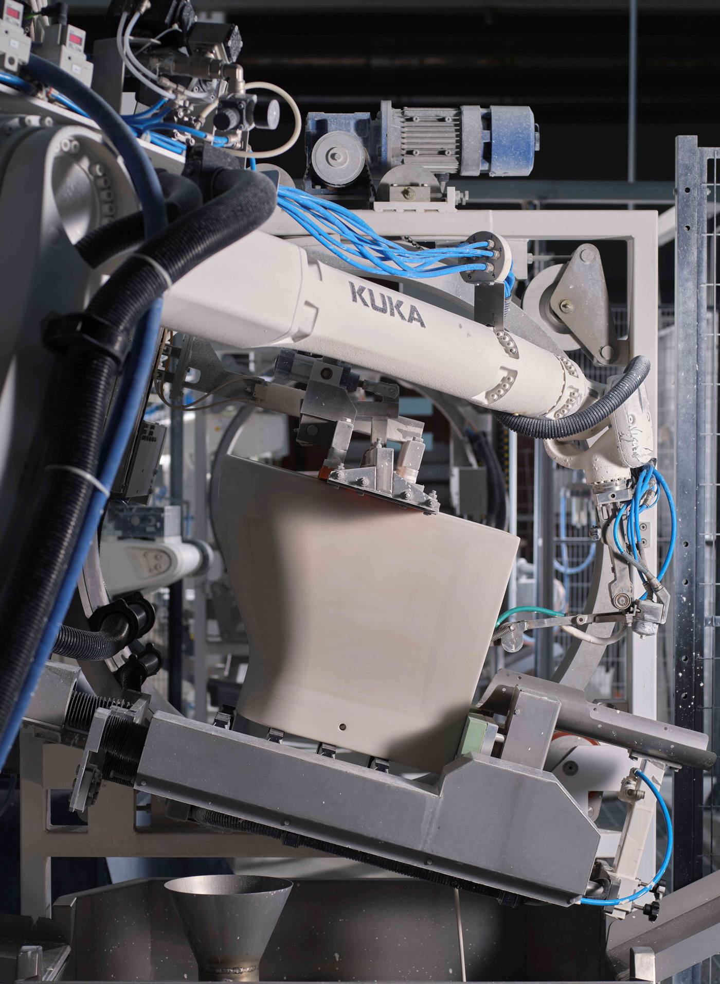 Dettaglio di robot KUKA che esegue la finitura di sanitari in ceramica con precisione millimetrica