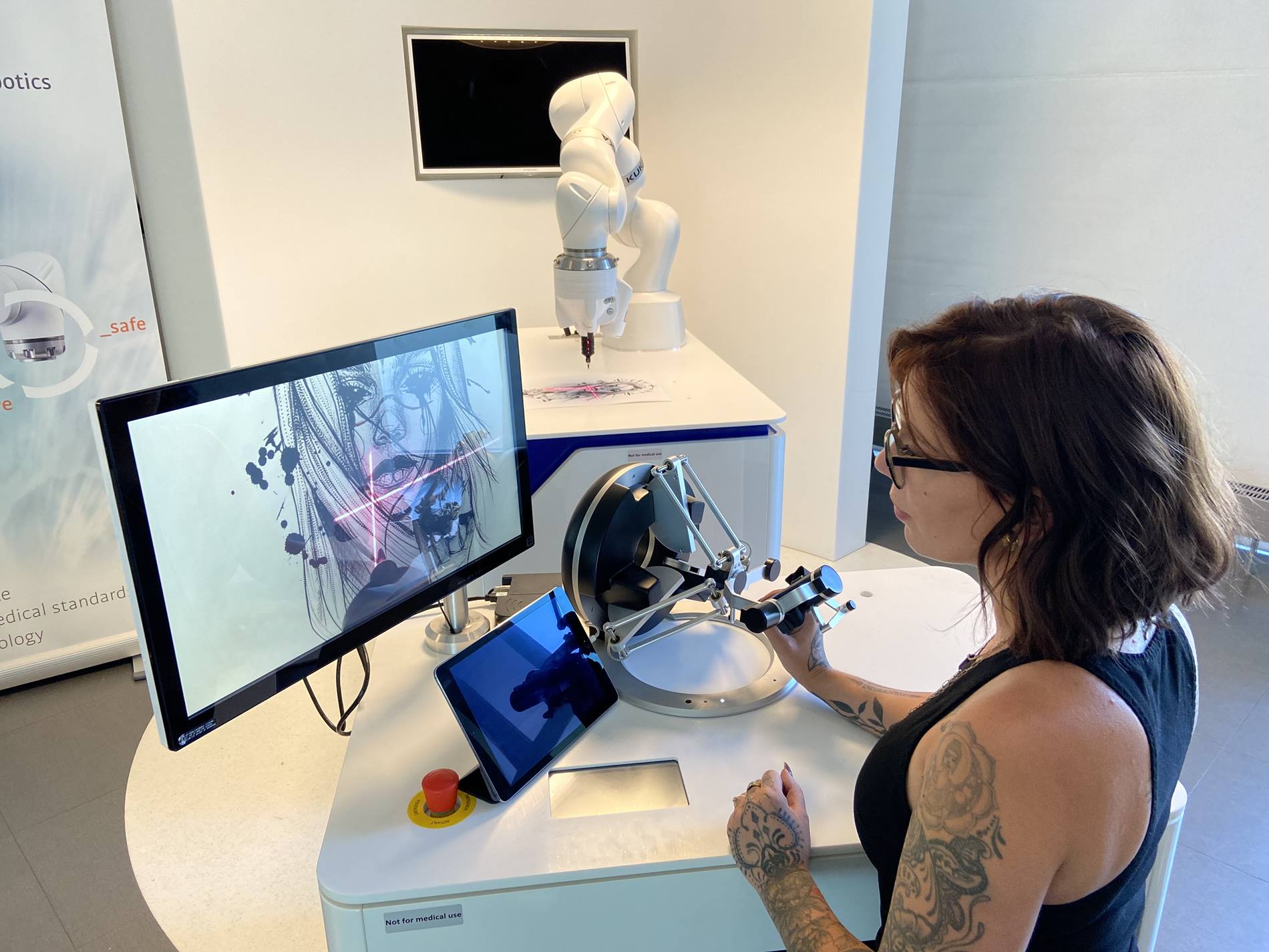 The tattoo artist Fauve Lex controls the KUKA Cobot and tells it how to move. 