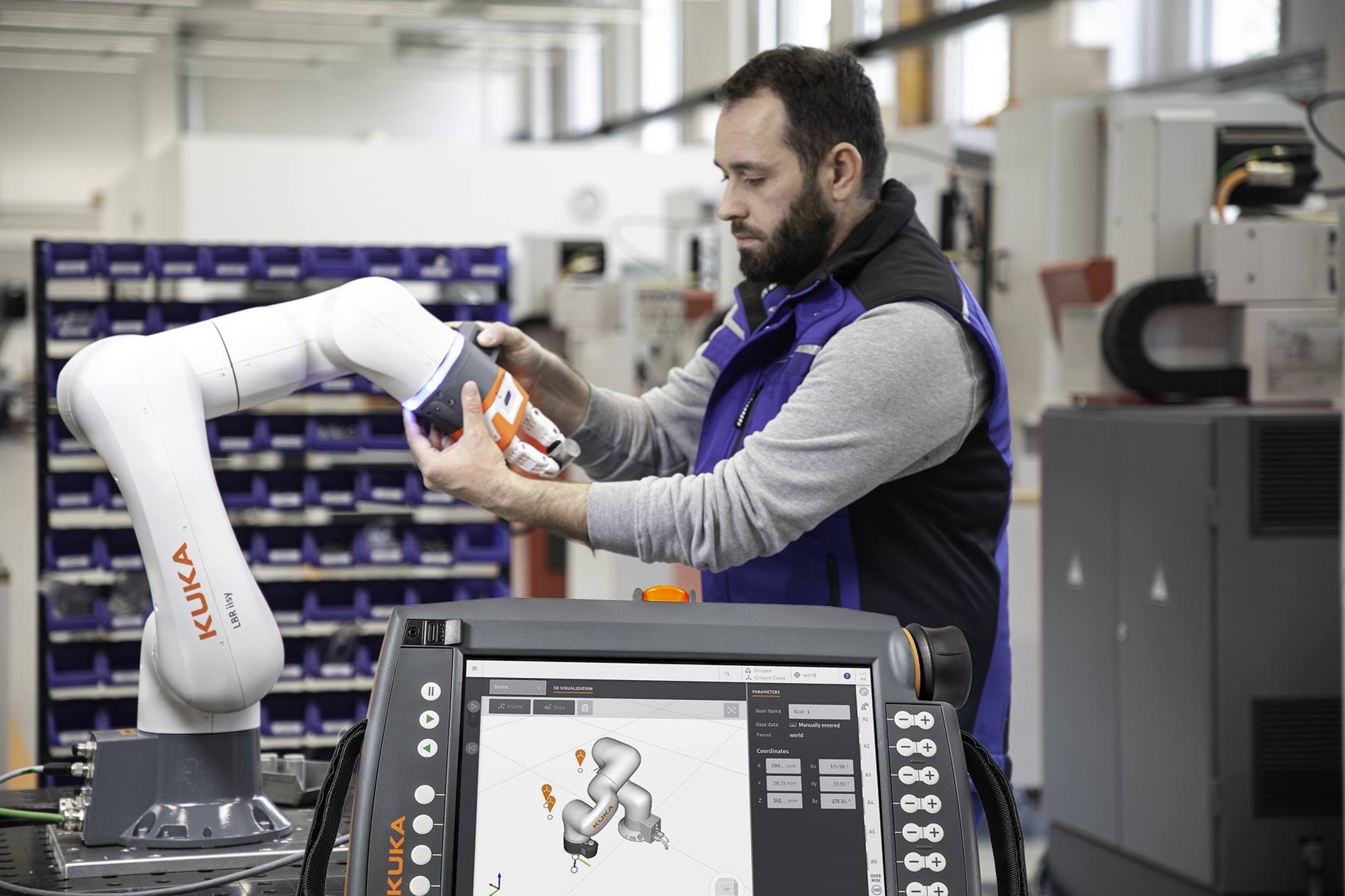 Man programs a KUKA Cobot LBR iisy by means of hand guidance. 