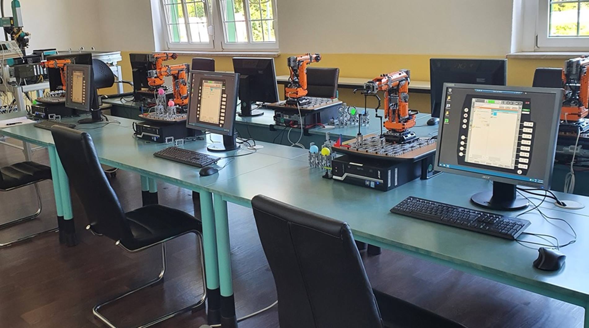 Ein komplett eingerichtetes Klassenzimmer aus Baustein-Robotern, die mit der virtuellen KUKA Steuerung programmiert werden. 
