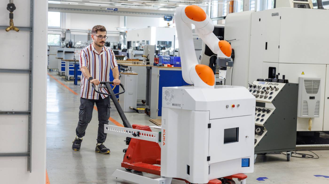 Ein Mitarbeiter transportiert den Cobot zu seinem nächsten Einsatzort.