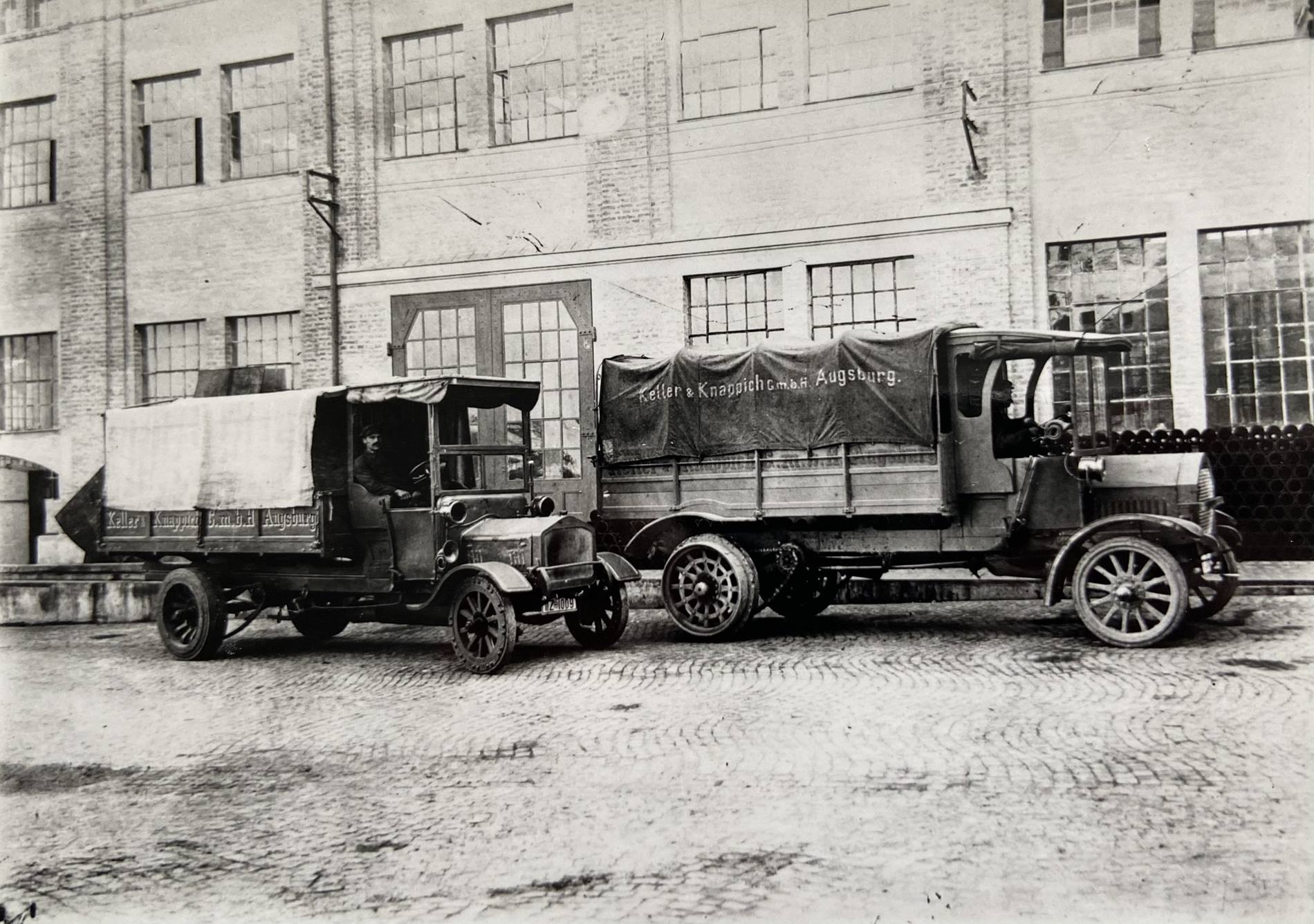 Historic trucks stand in front of a KUKA factory hall: KUKA is 125 years old. 