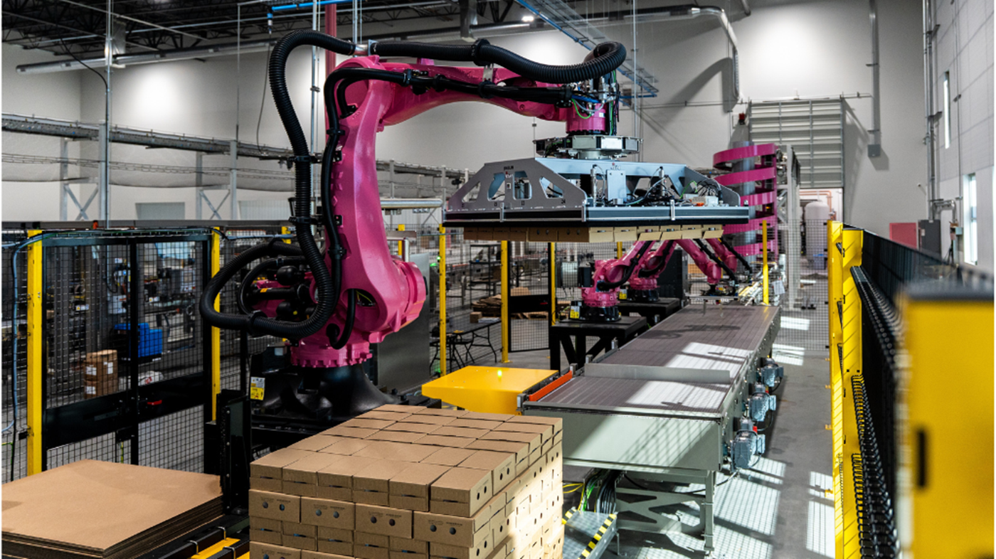 A line of robots handle and palletize cases of yogurt at Coconut Cult