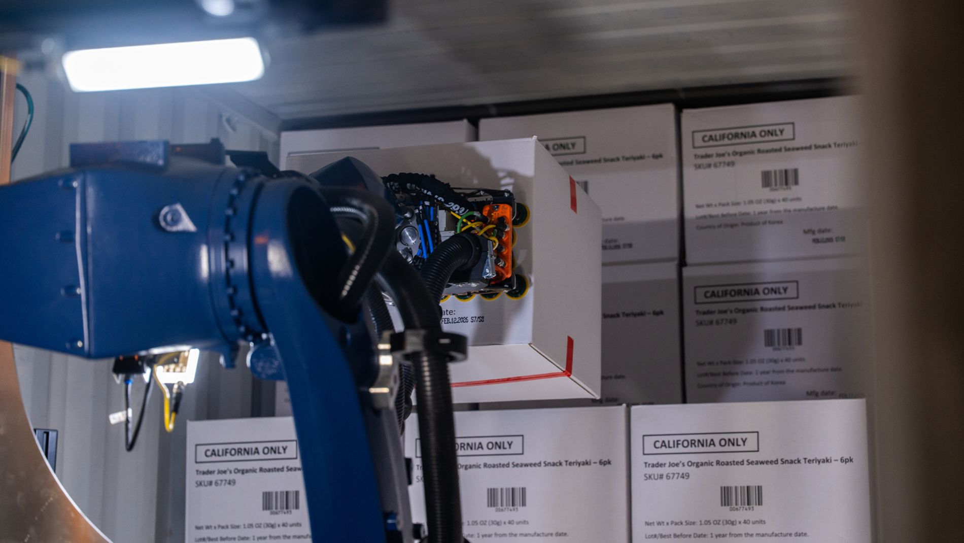 A KUKA Robots works in a tight space of a truck trailer to unload cases