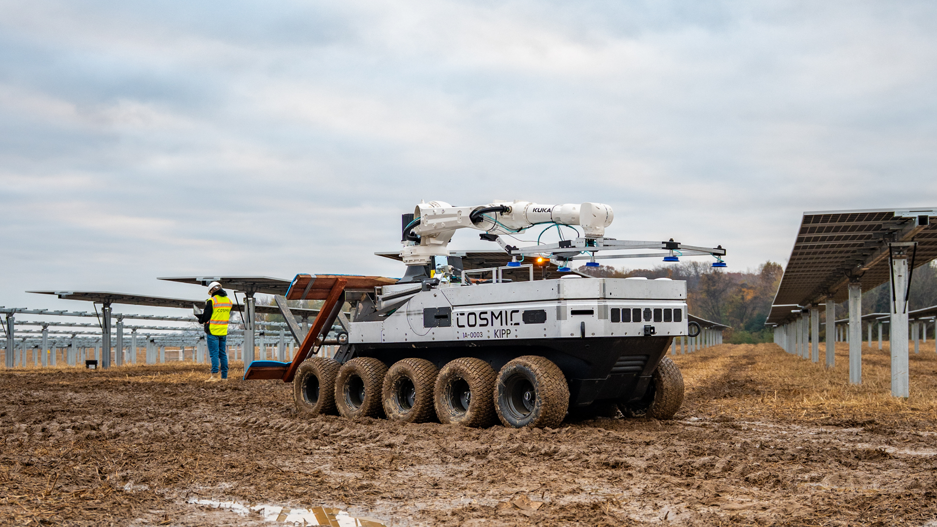 Workers collaborate with a robotic system to install solar modules in a large-scale renewable energy project.