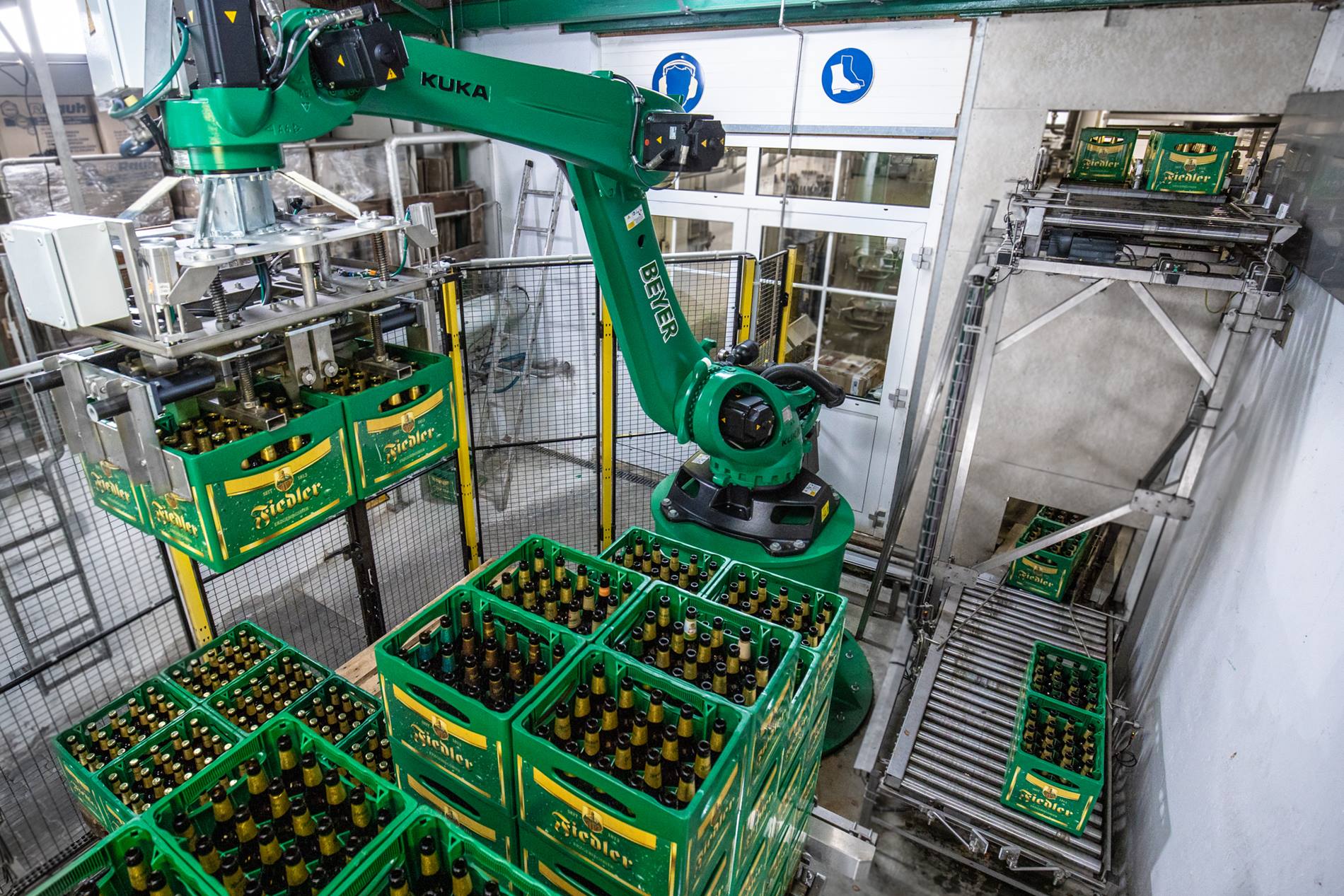 Een KUKA robot palletiseert de zware bierkratten 