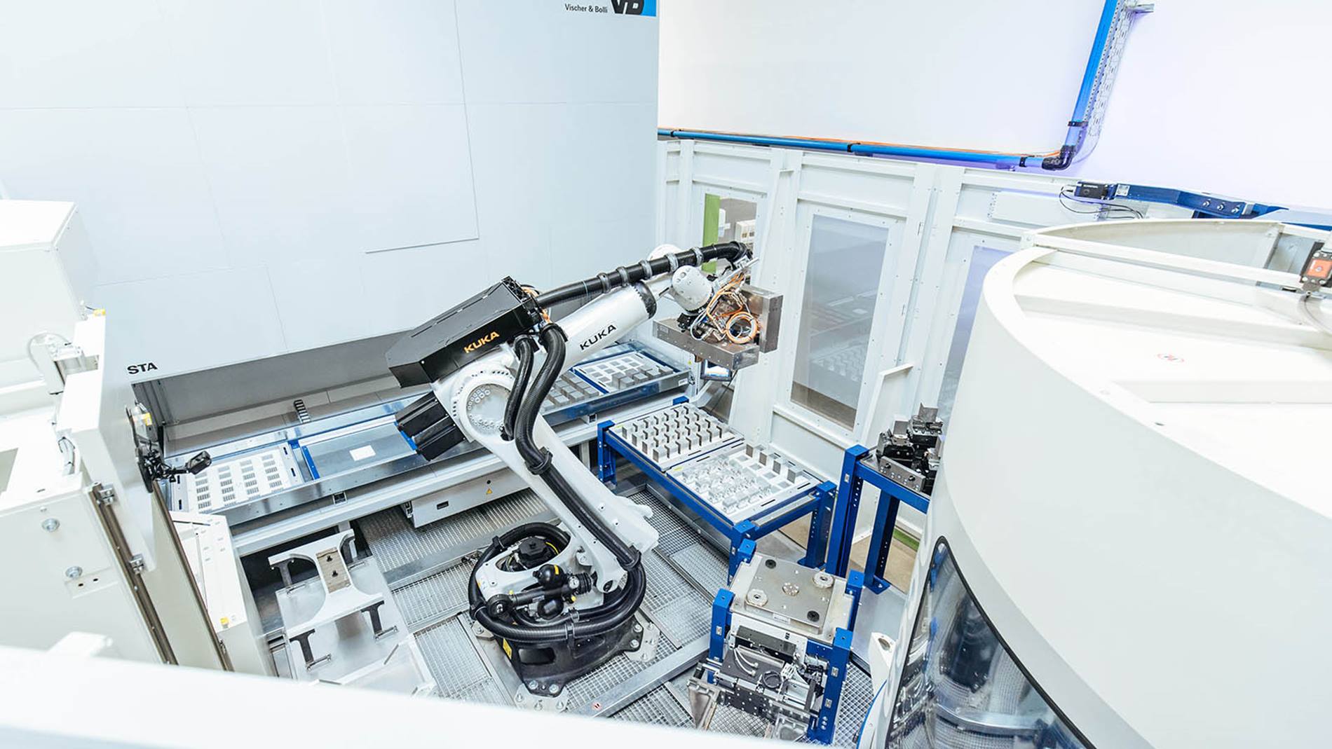 KUKA Roboter beladen die Fräsmaschine in einer modularen Zelle