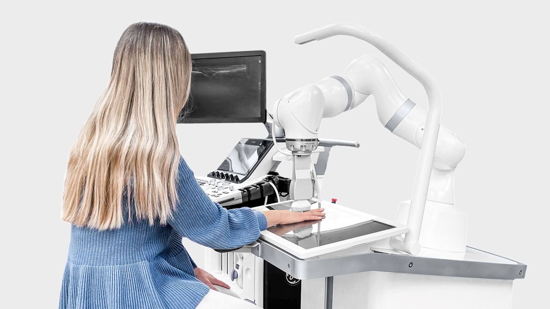 Woman sitting in front of the ARTHUR ultrasound robot from ROPCA