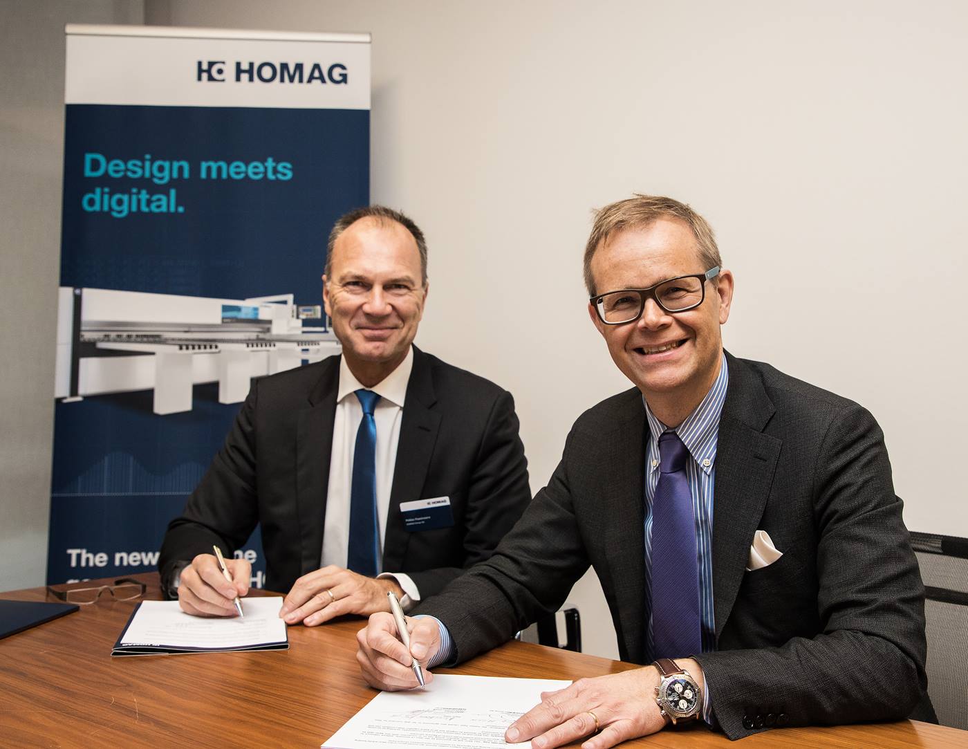 Stefan Lampa (right) signs the contract between HOMAG Group and KUKA. 