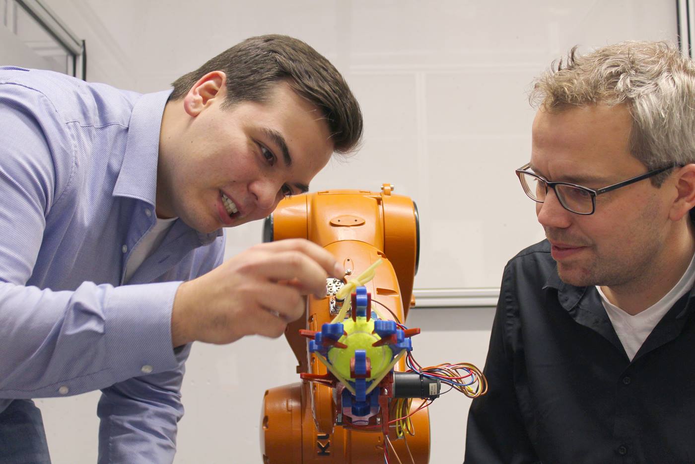 Professor und Student arbeiten am KUKA Roboter