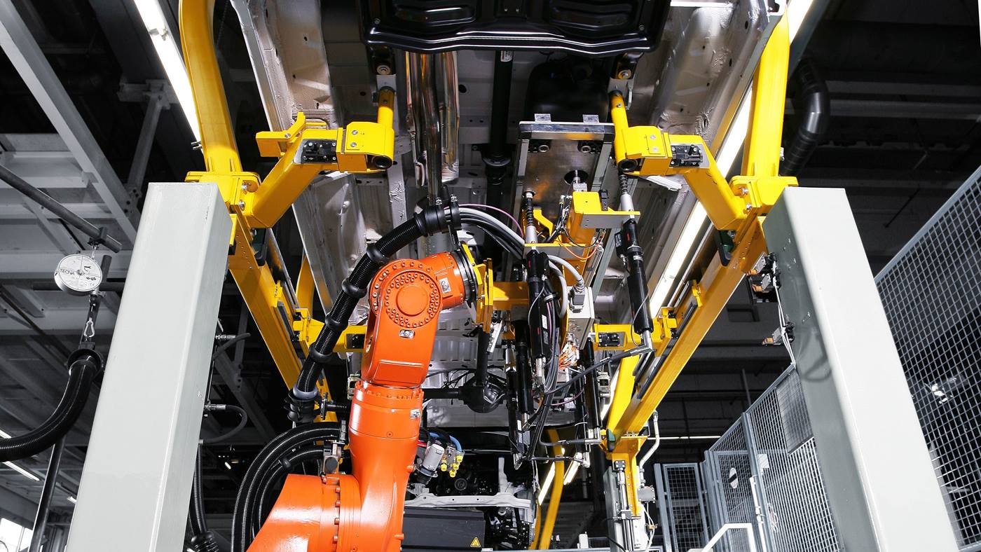 KUKA Roboter (KR CYBERTECH) beim Montieren eines Fahrzeugunterbaus. 