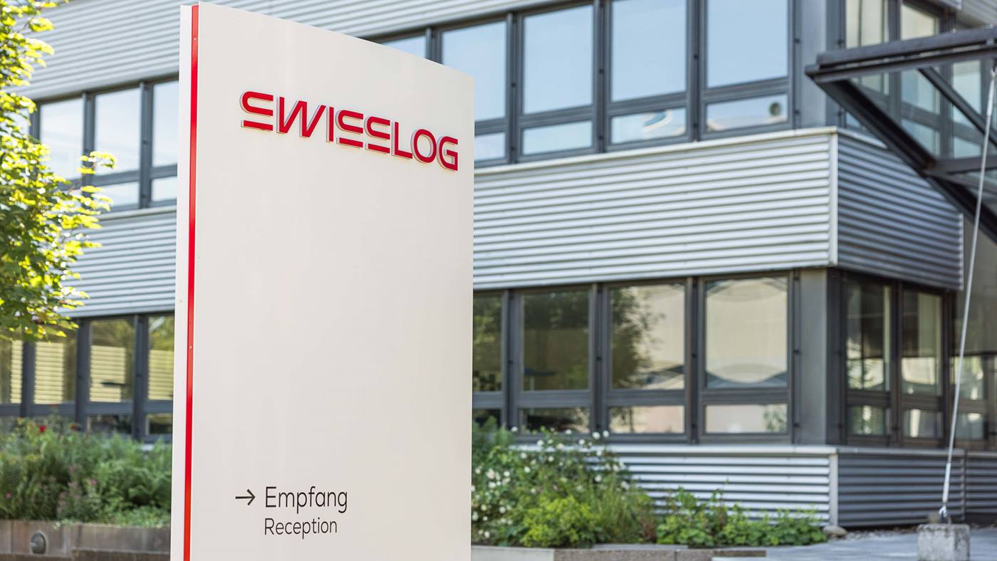 Swisslog headquarters building in Buchs, Switzerland with the new Swisslog logo